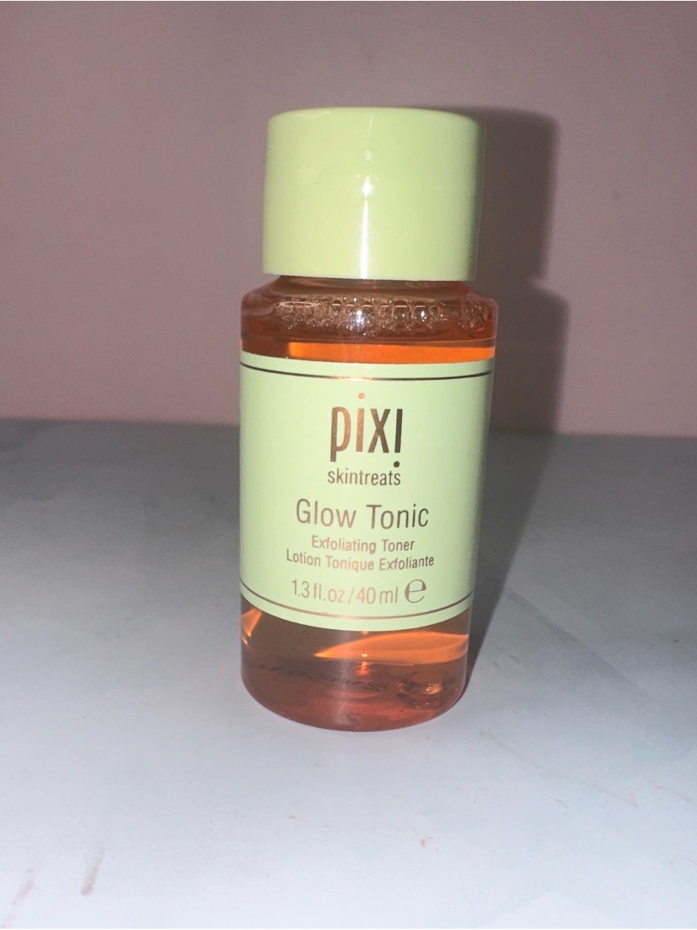 Pixi Glow Tonic in Light Green Cap and Label with Orange Liquid